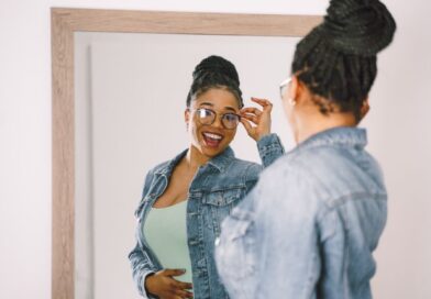 Mulher negra sorrindo, se olhando no espelho